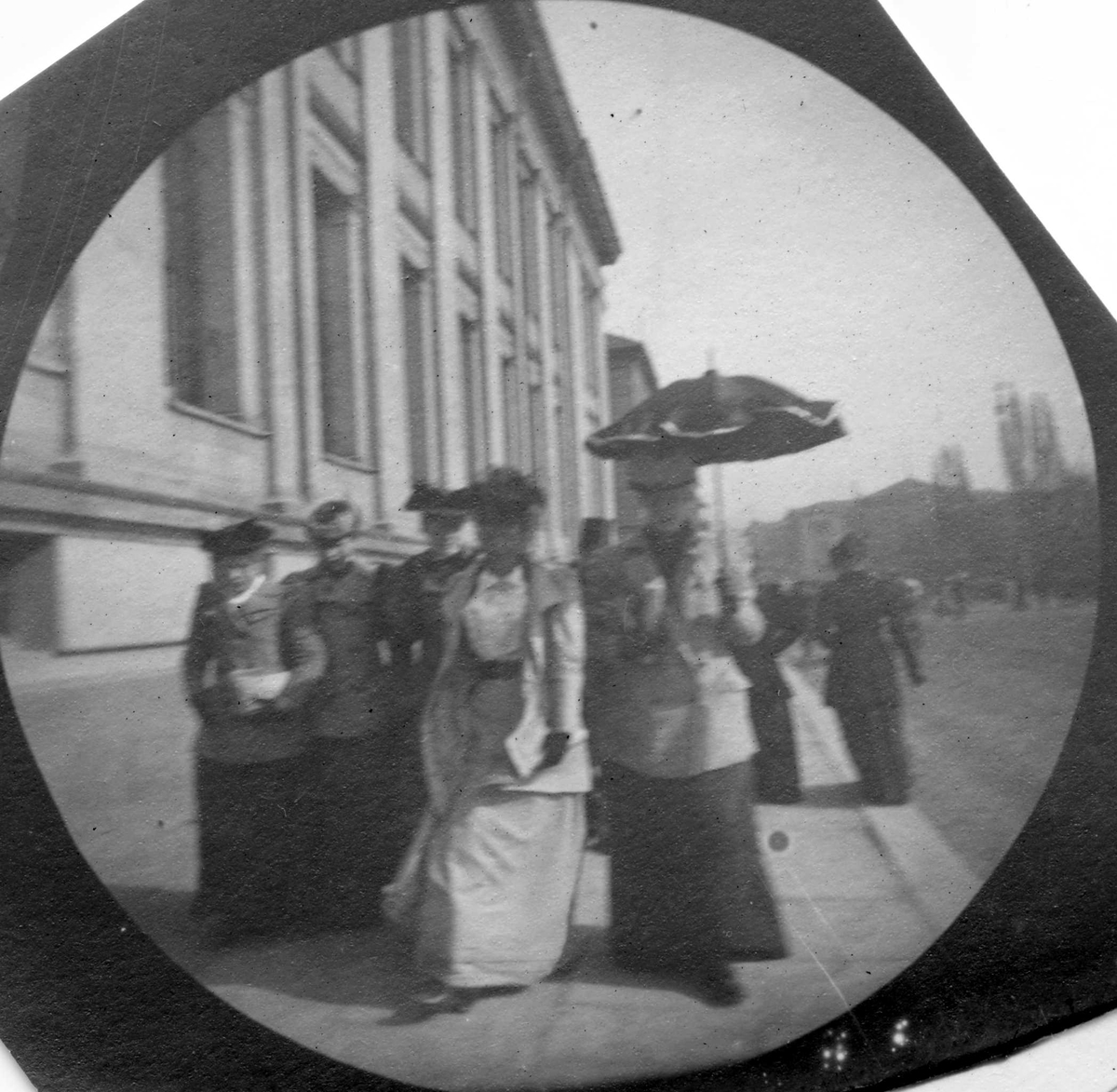 Fredrik Carl Mülertz Størmer, Frk. Maren Astrup, frk. Solveig Berg og frk. Ellen Wille spaserer langs Universitetet, Karl Johans gate, Oslo.
