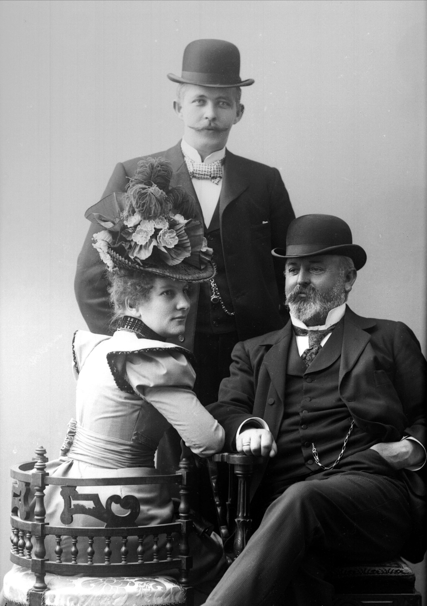 Gustav Borgen, Gruppe, kvinne og mann ved bord, mann bak, alle med ytterklær på. Kaptein Rosendahl.
