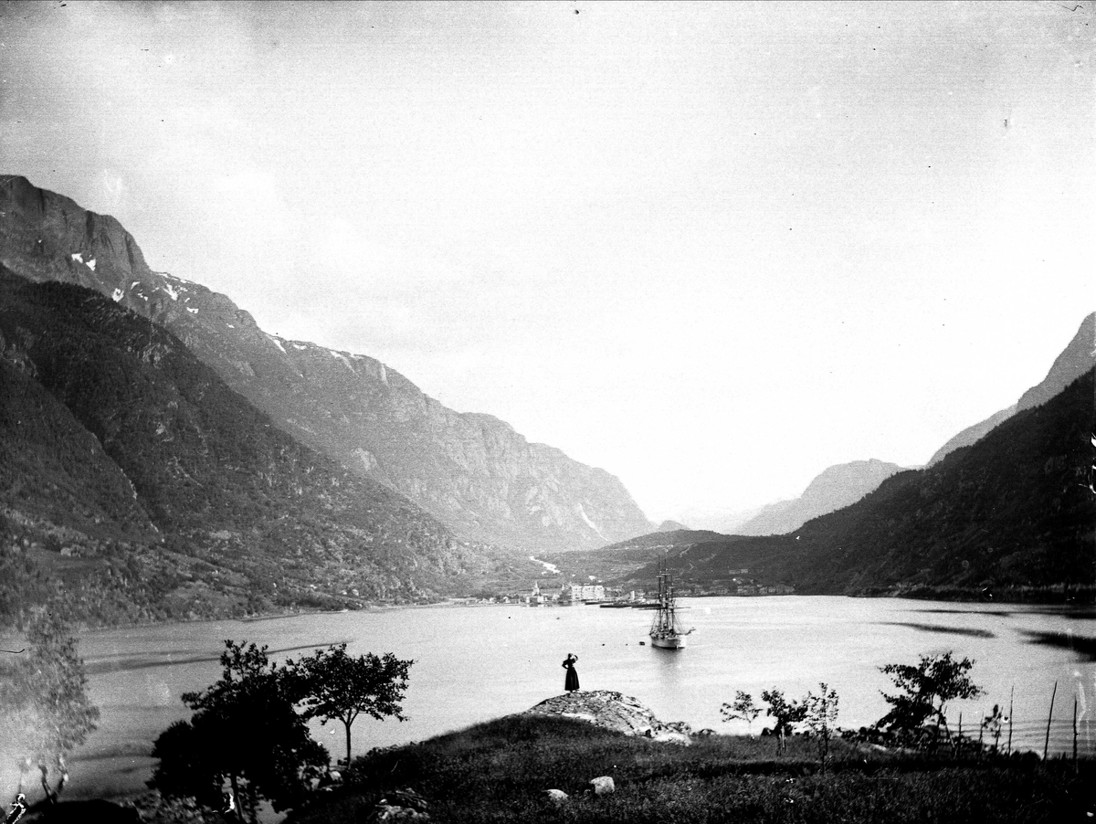 Solveig Lund, Landskapsfotografi fra Odda i Hardanger. I forgrunnen sees Sørfjorden med seileskute og i bakgrunnen fjell.