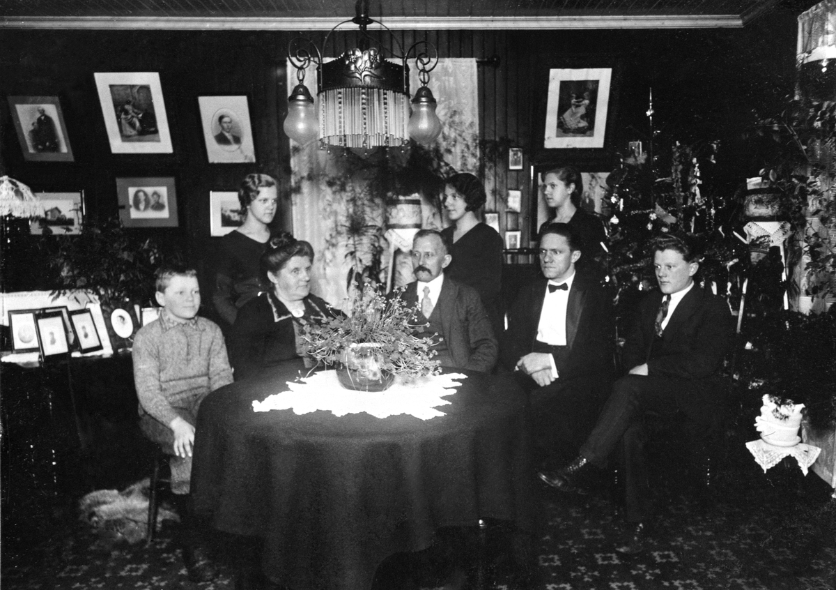 Anno Domkirkeodden, Interiør, stue, gruppe, familie samlet rundt bord, juletre.. De tre unge i bakgrunnen er fra venstre: Hjørdis Hagen, Magna Hagen (g.Johansen og min mor) Ymbjørg Hagen g. Holstein. Foran: Åge Hansen ( hans senere kone het Løvhaug, men ikke han).Mina Hagen, Johannes Hagen, Sverre Hermandsen, Alf Herm…