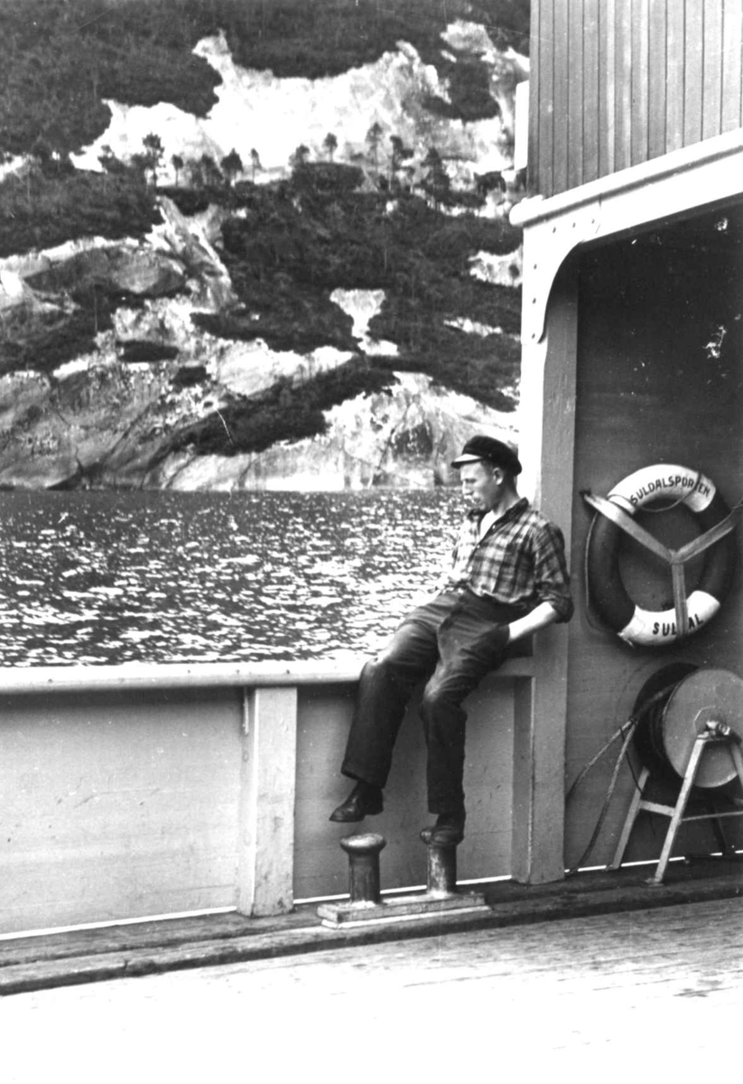 Anna Grostøl, En mann sitter på ripa på motorbåten innover Suldalsvatn. Suldal, Rogaland 1939.
