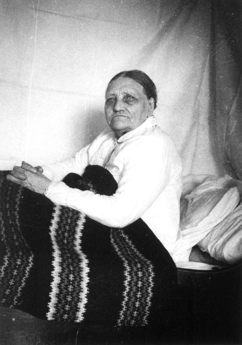 Anna Grostøl, Fru Åselina Eiken sitter i sengen sin. Eiken, Hægesbostad, Vest-Agder 1937.