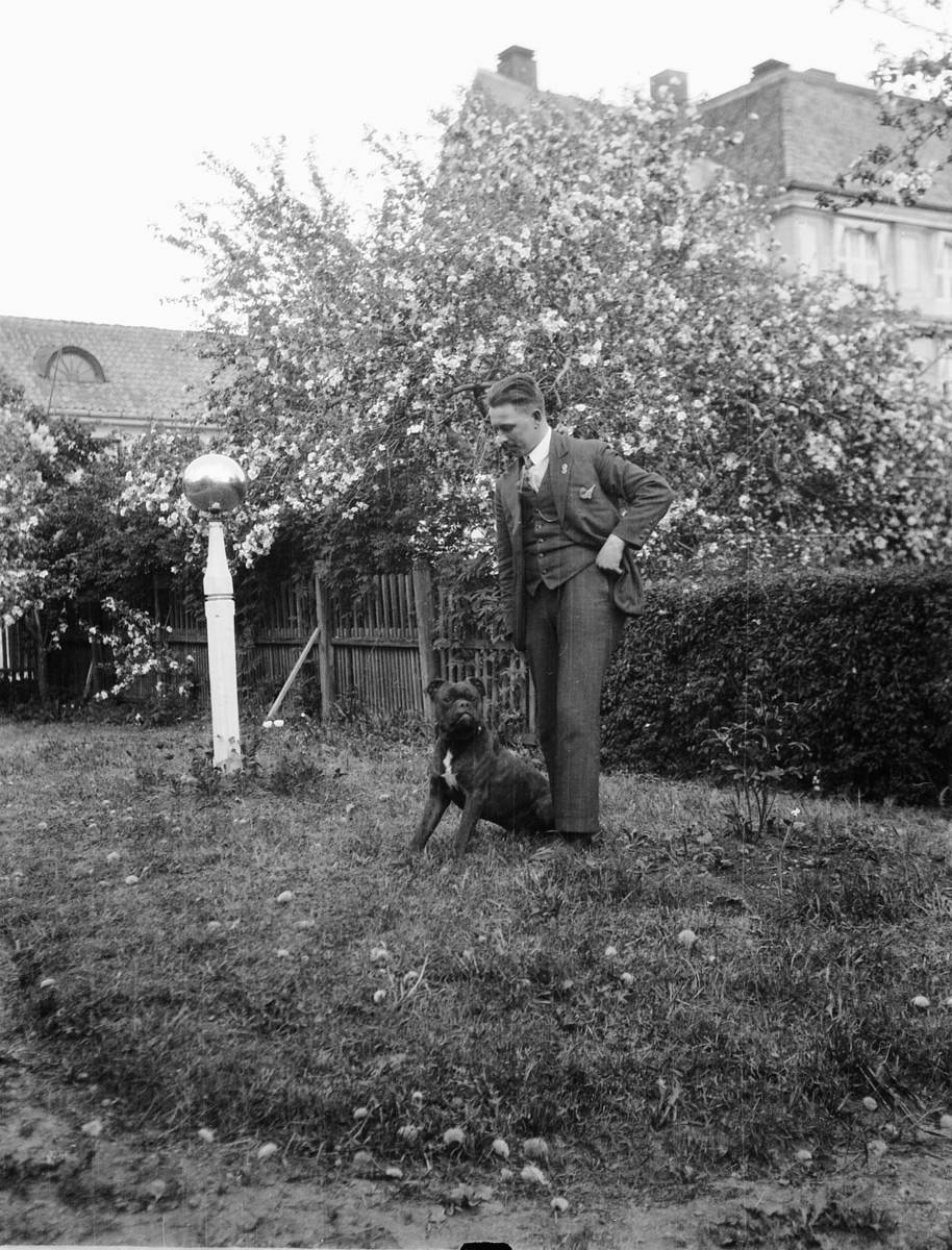 Ragnvald Andersen, Eksteriør, hage. Ukjent mann med en hund. Glasskule på stang.