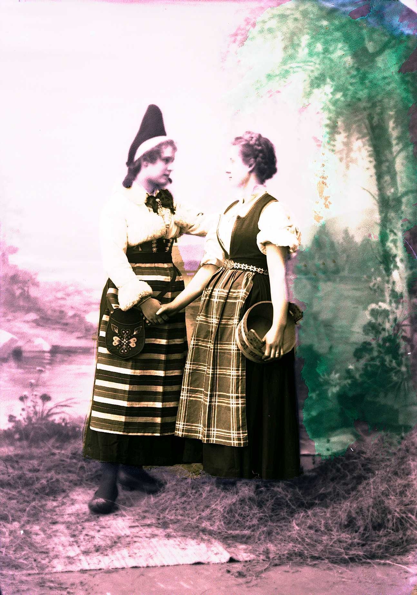Solveig Lund, To kvinner i drakt tar hverandre i hånden. En holder en ambar under armen. Malt bakgrunn med landskap, høy på gulvet foran teppet.