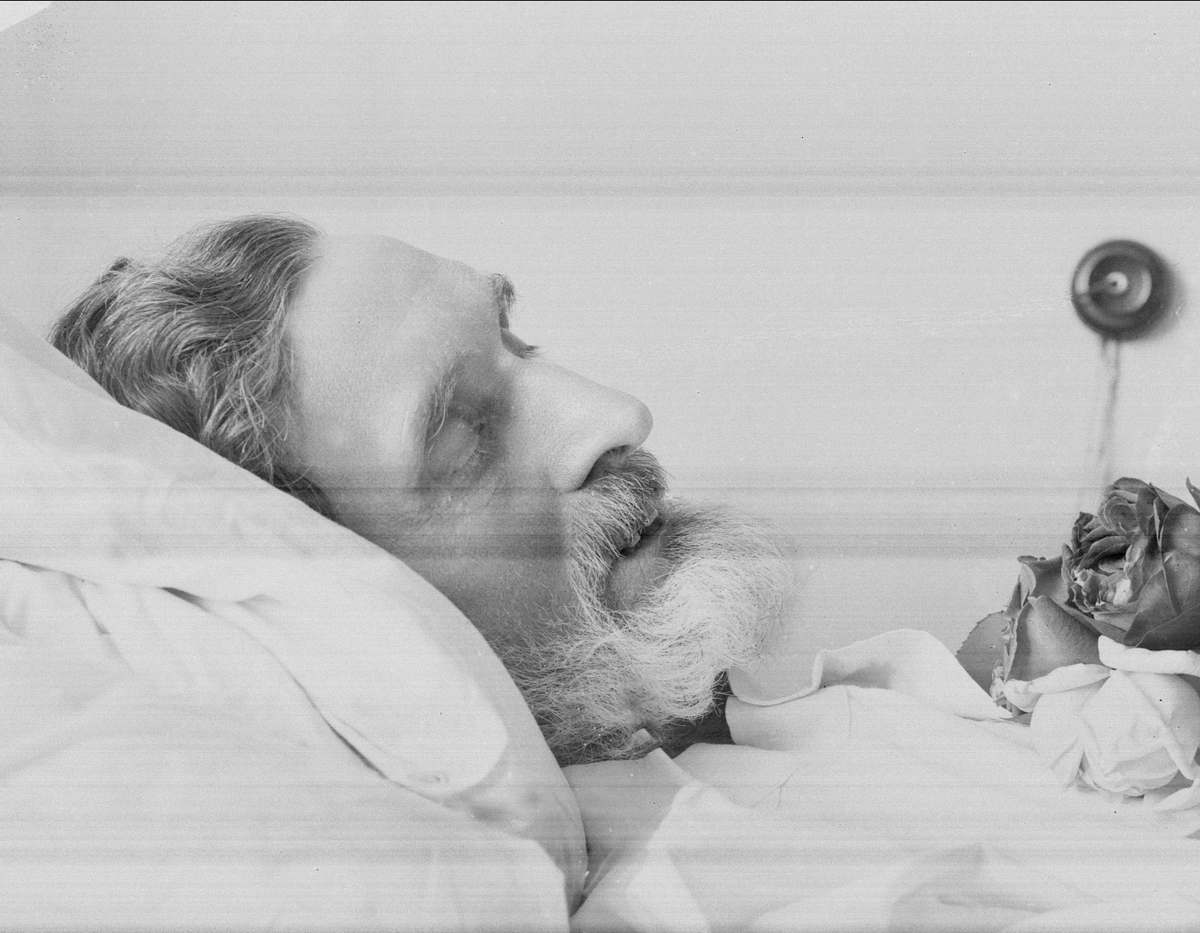 Gustav Borgen, Post mortem-fotografi. Død mann i pyntet seng. Trolig på sykehus.
