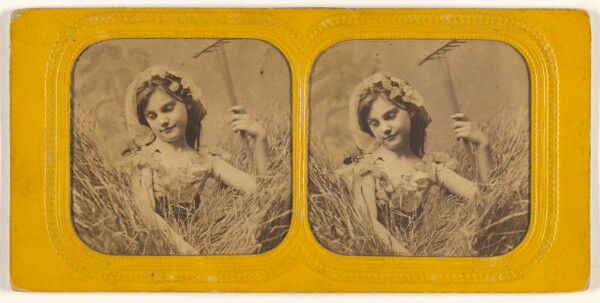 Unknown, [Little girl in field of hay holding a rake]