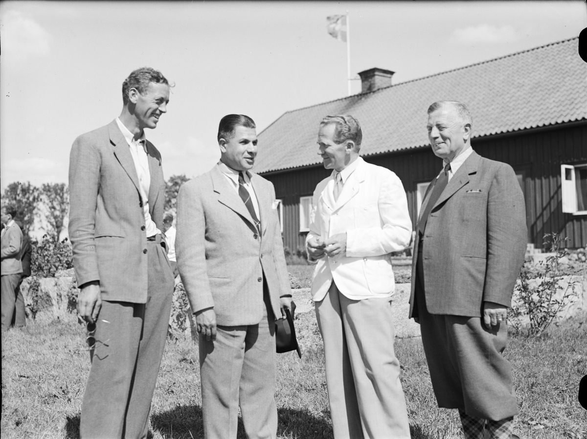 Paul Sandberg, Fyra män framför byggnad, Uppland 1947