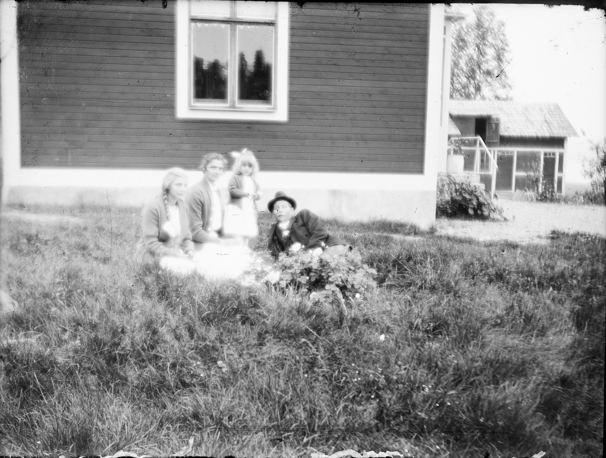 Skötsner-Edhlund, Familj i trädgården med bostadshuset i bakgrunden, Östhammar Uppland