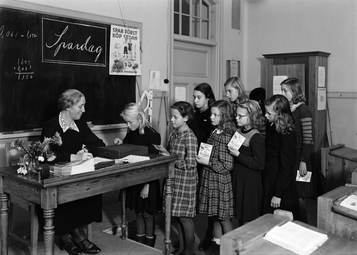 Paul Sandberg, Saving Day at Sverkerskolan, Uppsala, October 1944. The girls queue to leave their mittens to teacher Ester Andersson