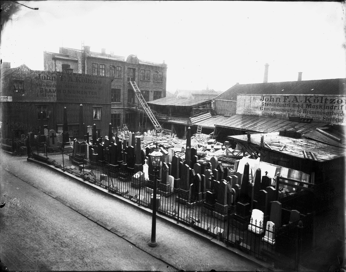 Marthinius Skøien, Oversiktbilde fra John F. A. Køltzows "Stenhuggeri, Sliberi og Lager af Gravmonumenter", Akersveien 06-10, Hammersborg, Oslo. Bygninger og gravstøtter på gårdsplass.