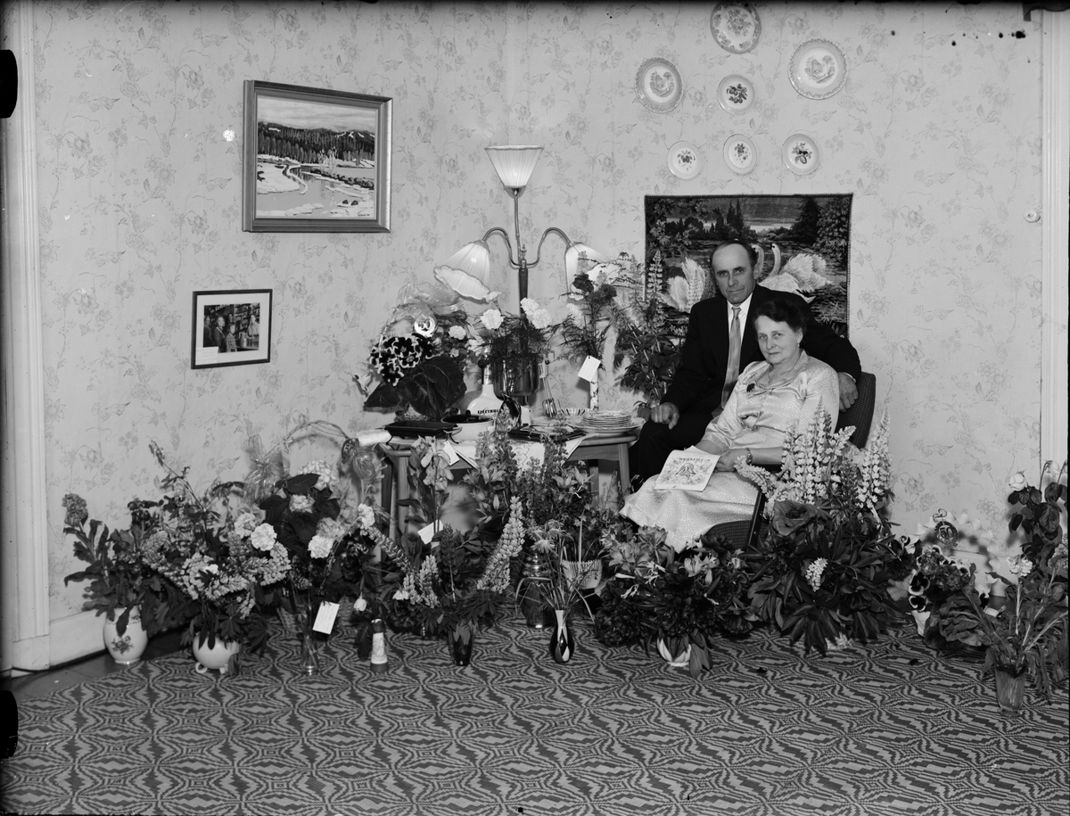 Skötsner-Edhlund, Woman and man in a home environment surrounded by flowers, Östhammar, Uppland