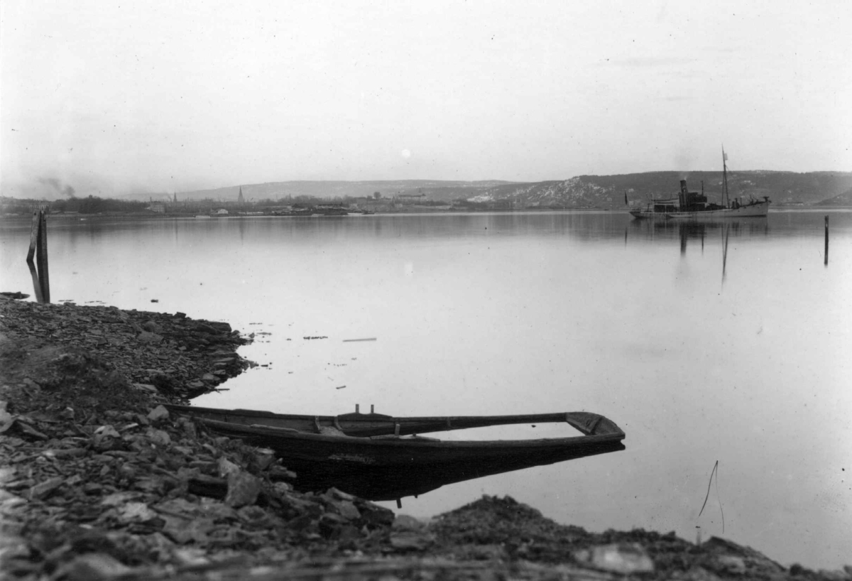 Hermann Christian Neupert, Bygdøy, Oslo 1908-1910. Oversiktsbilde. Ved Dronningen, aftenstemning i strandkanten med pram full av vann og dampbåt på vannet. Bebyggelse i bakgrunnen.