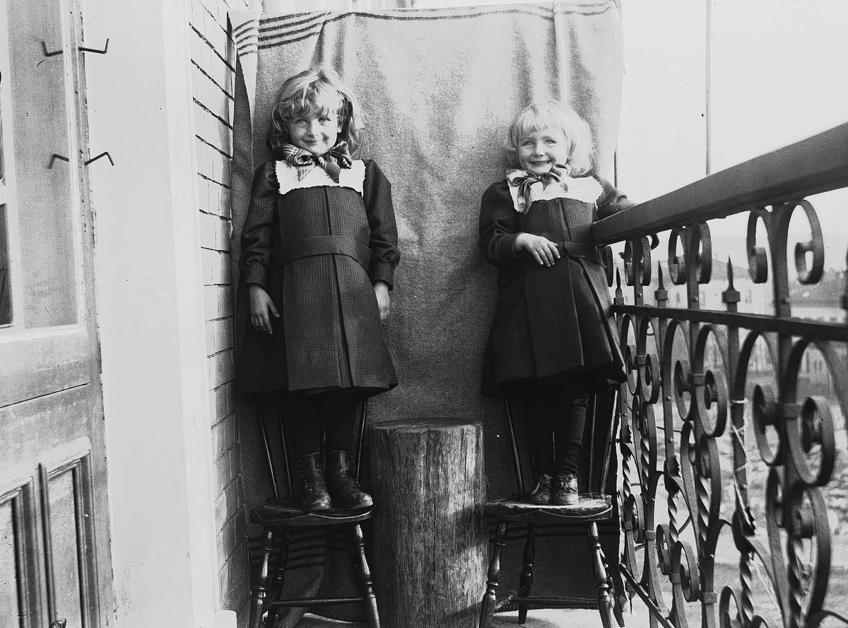 Axel Quinsgaard Wiborg, Gudrun og Karen Q. Wiborg fotografert på balkong, ant Meltzers gate 9, Oslo, 1899, mot opphengt bakteppe.