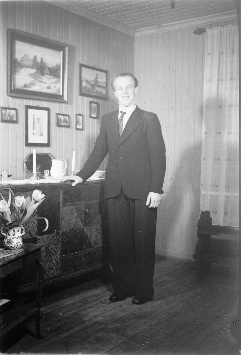 Håkon Prestkværn, Interiør, stue. Ukjent mann i dress.
