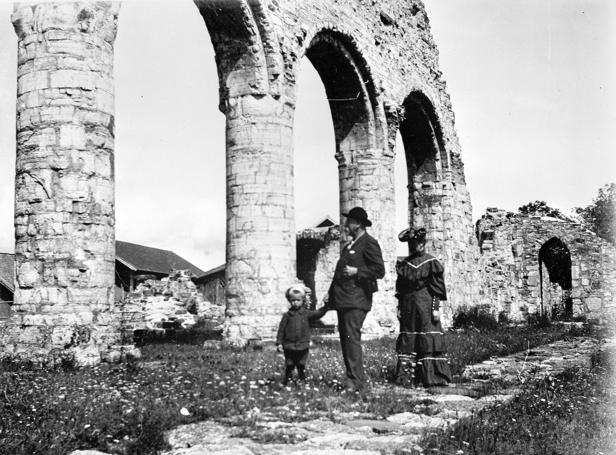 Anno Domkirkeodden, EKTEPAR MED BARN I SØYLEGANGEN PÅ DOMKIRKERUINEN, HEDMARKSMUSEET OG DOMKIRKEODDEN