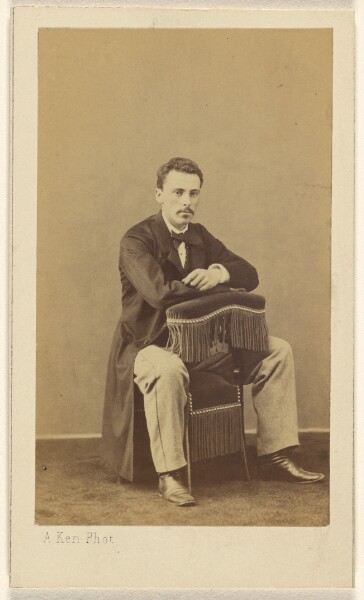 Alexandre Ken, [Man with moustache, seated, with front to back of fringed chair]