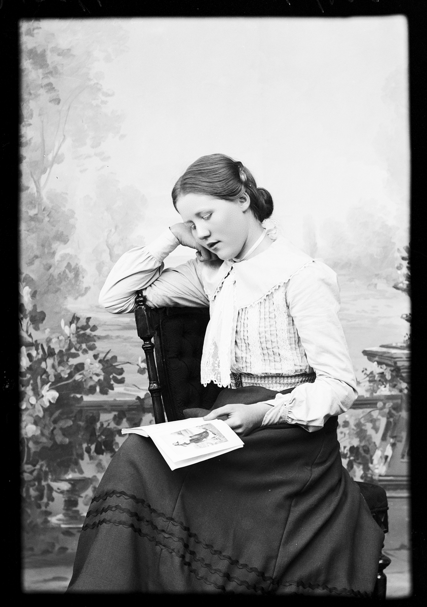 Skötsner-Edhlund, Ateljé portrait - Ruth Skötsner sits and reads in a book, Östhammar Uppland 1903