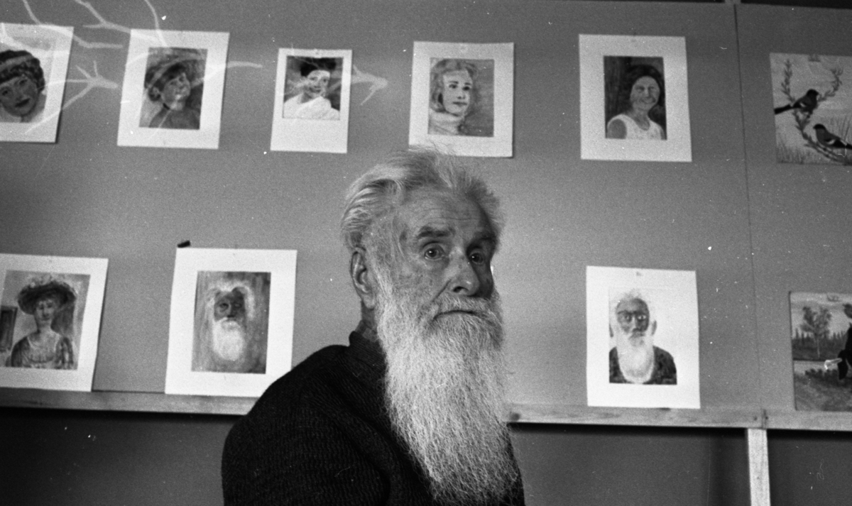 Örebro Kuriren, Ryss målar 18 april 1966 En rysk man med långt silvervitt hår och skägg. I bakgrunden syns en vägg fylld med målningar som han har gjort. Han är klädd i mörk tröja. or. Han går nedför en kort trappa utomhus.