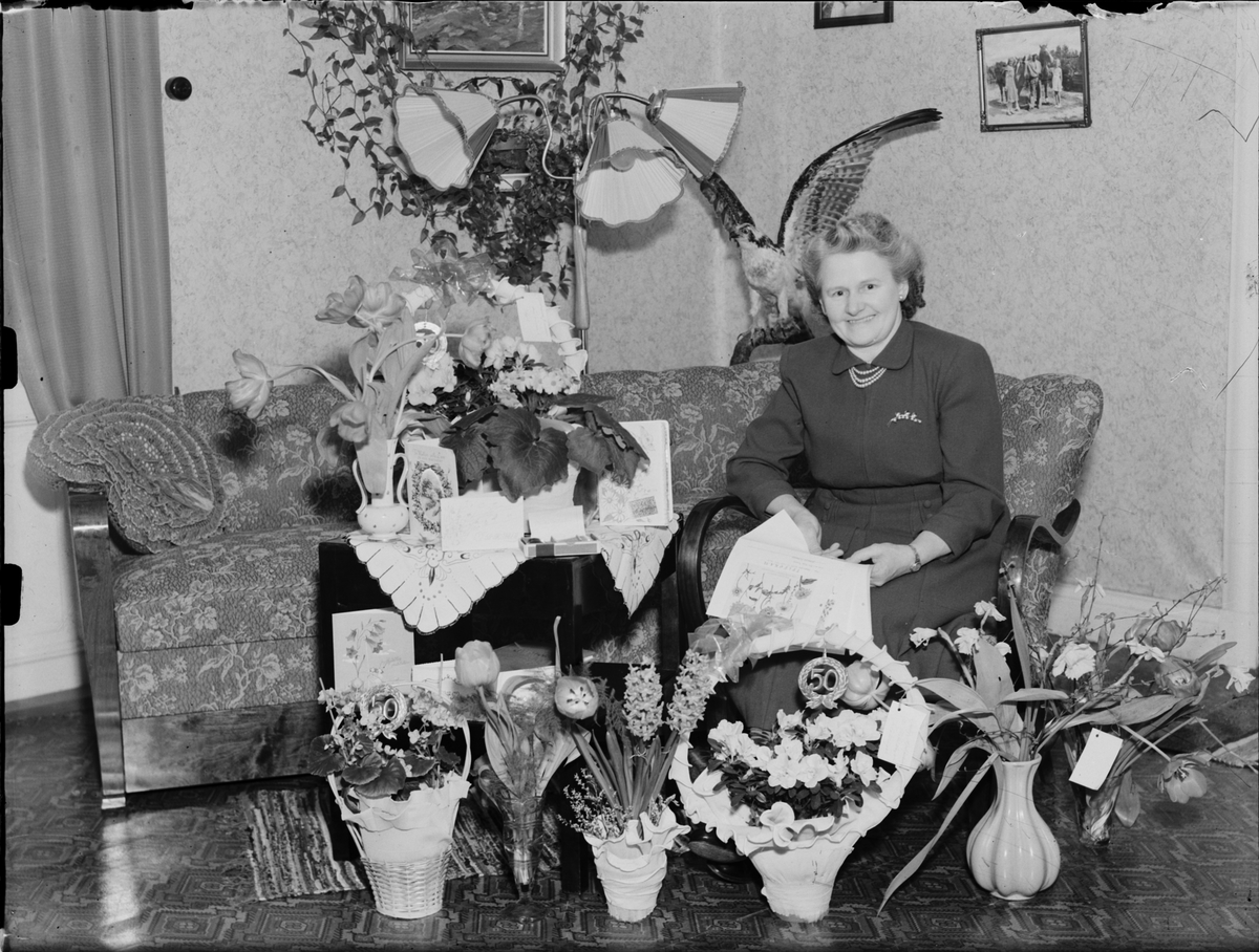 Skötsner-Edhlund, Kvinna i hemmiljö omgiven av blommor, Östhammar, Uppland,