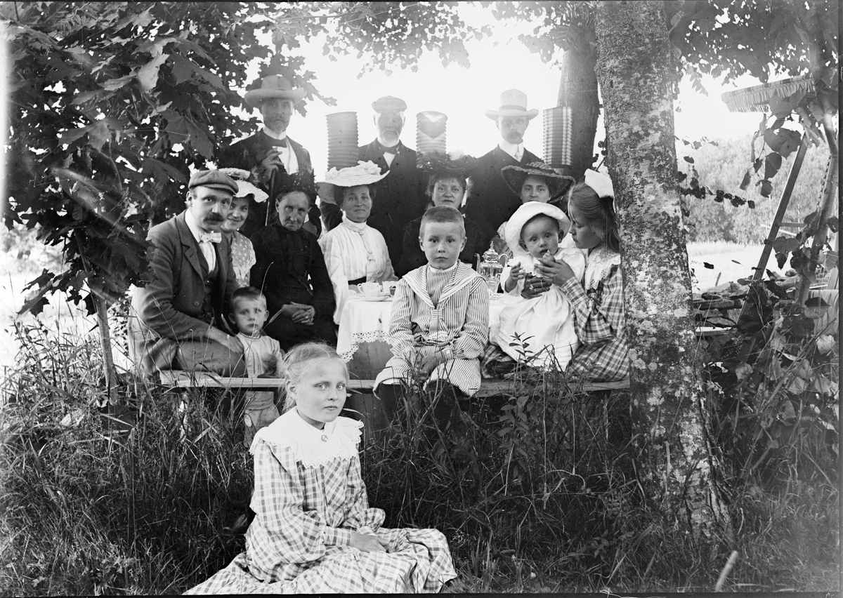 Okänd,, Ruben och Christiane Liljefors med familj och släkt sittande ute i trädgård, sannolikt i Sverige