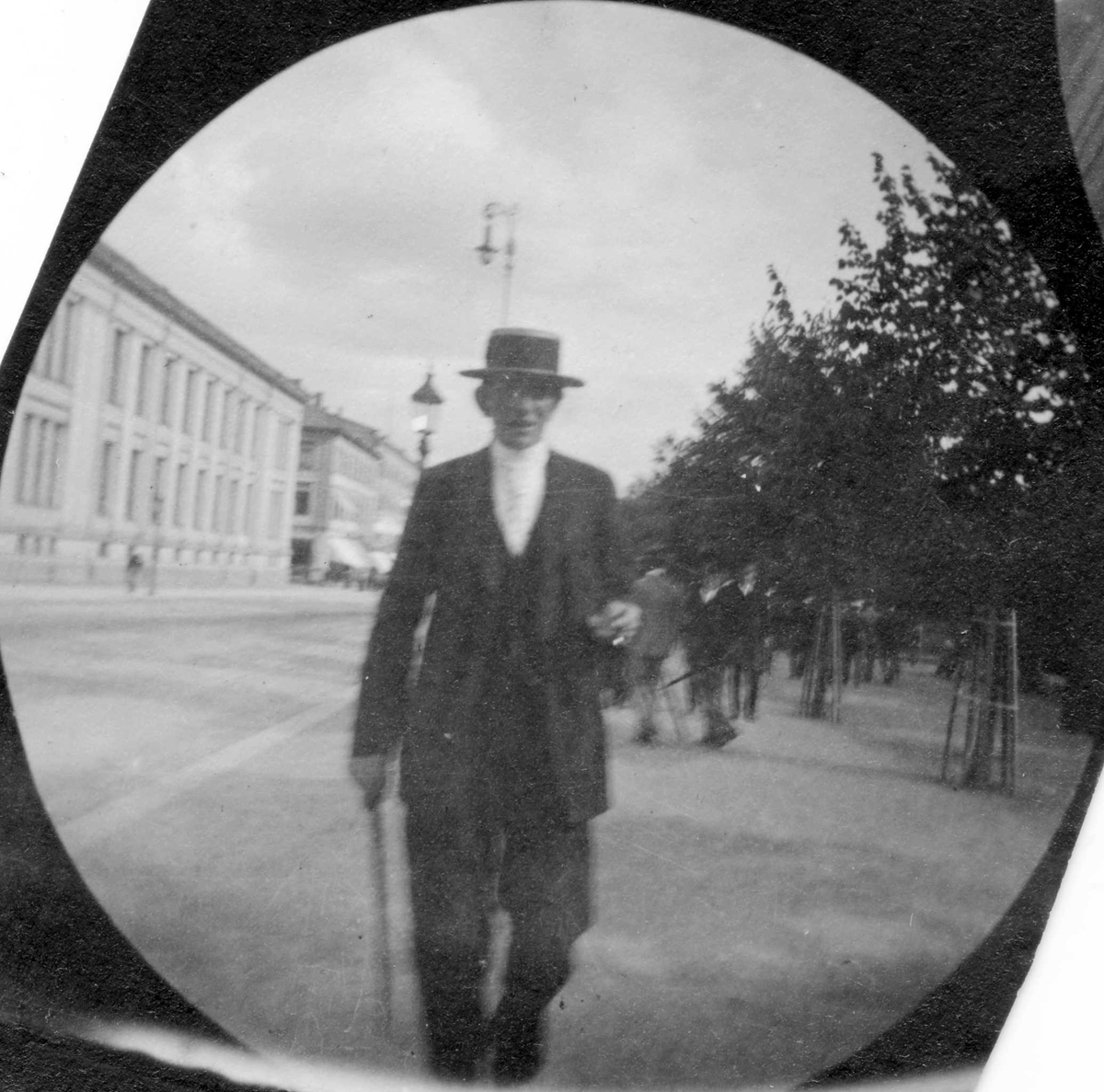 Fredrik Carl Mülertz Størmer, Tom Vogt, student fra 1892, spaserer langs Karl Johans gate, Oslo, i Studenterlunden. Universitet på andre siden av gata.