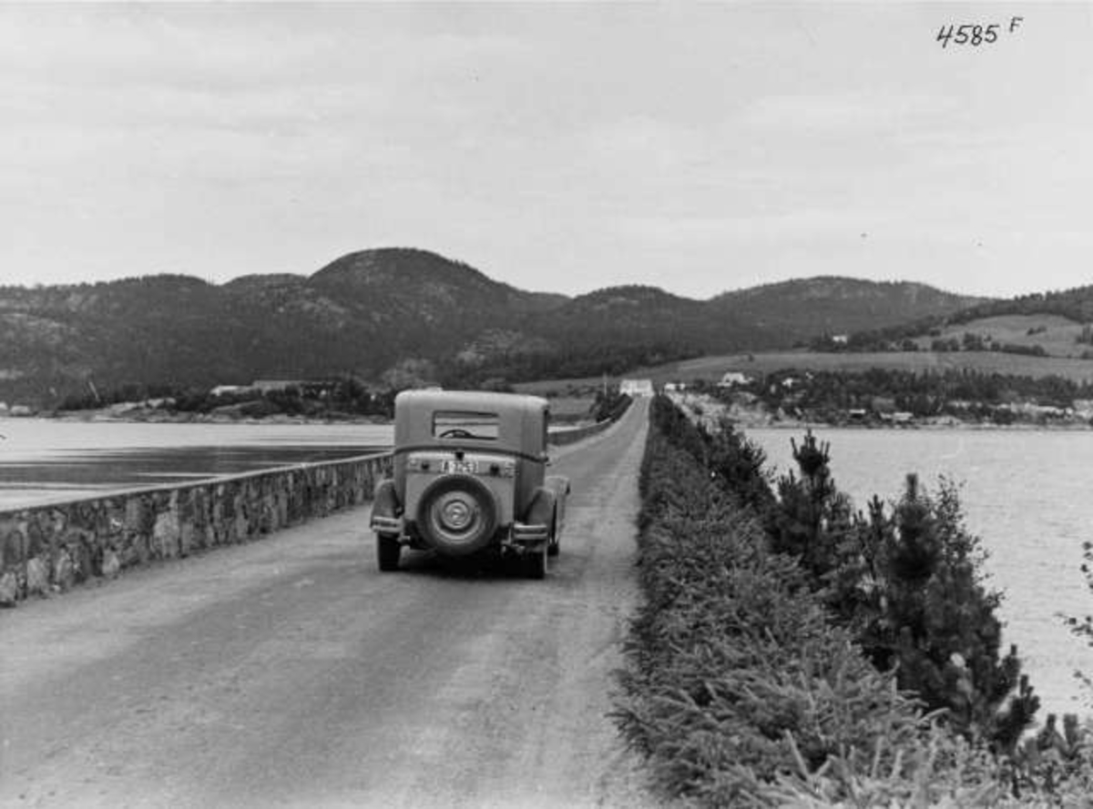 Anders Beer Wilse, Veiparti med bil ved Namsbrua over Namsen mellom Namsos og Spillum, Nord-Trøndelag, 1936, Riksveg 17 i dag. Fra protokoll:" Trøndelag Namsenbroen 1936"