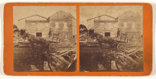 Unknown, [Horse-drawn wagon in front of wooden building]