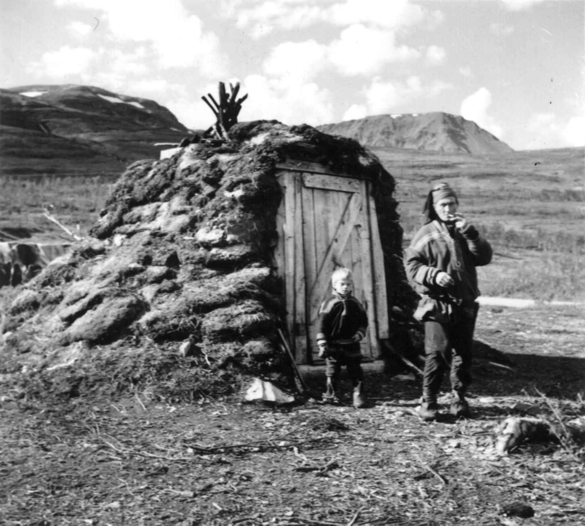 Virginia Raymond Davidson, Johan Johansen Eira og hans sønn fra Kautokeino står foran sommergamme. Kvænangsfjellet 1957.