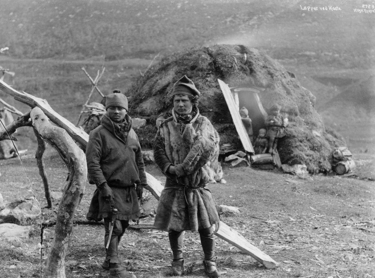 Axel Lindahl, To svenske samer fra Karesuando foran en gamme, tre barn i døråpningen. Antagelig Tromsdalen ca. 1885-1892.