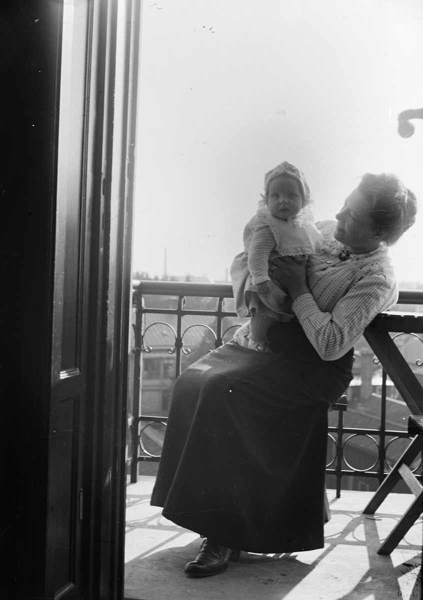Okänd,, Woman sitting on a balcony with a little girl in the fist, probably in Sweden