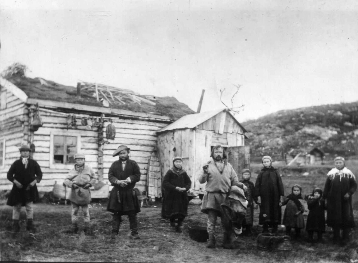 Ellisif Rannveig Wessel, Familien Ole Persen Savio og Jon Andersen Must foran Musts hus, Sandnes, Sør-Varanger, Finnmark, før 1900. Sjøsamer.