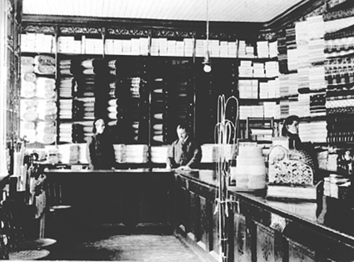 Anno Domkirkeodden, Butikkinteriør med fordisk og bakdisk, reoler, M. Murstads forretning i Storhamargata. 12. Tekstilutsalg. Forretningen hadde fått elektrisk lys så tidlig som 1899.