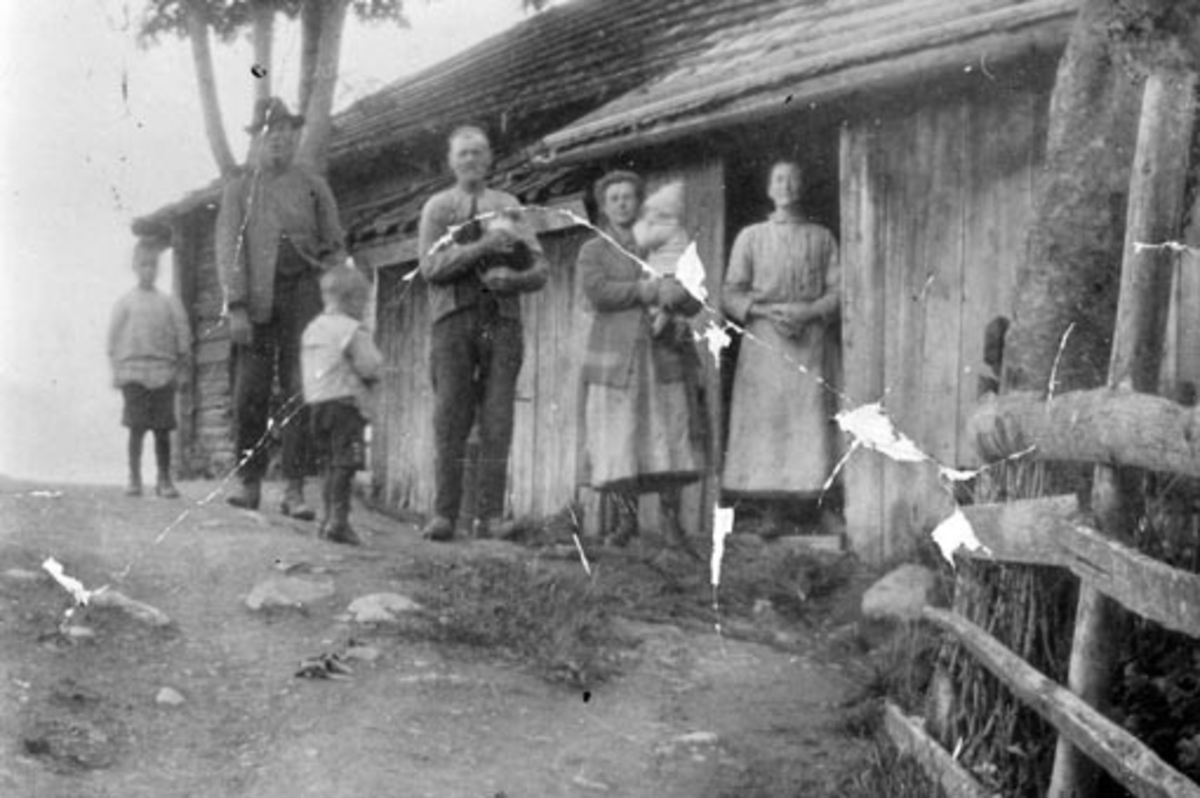 Anno Domkirkeodden, Eksteriør Myhrhagen, den gamle stua, gruppe 7 foran: Familien Myhrehagen, Myrhagen, Nes. Fra høyre Martin Myhrehagen f. 1903, Christian Myhrehagen f. 1861, Helga Myhrehagen (gift Paulsen) f. 1892 med datteren Ruth Maria Paulsen f. 1926 på armen, i døra Elise Dorthea Myhrehagen (pikenavn Martinsdatt…