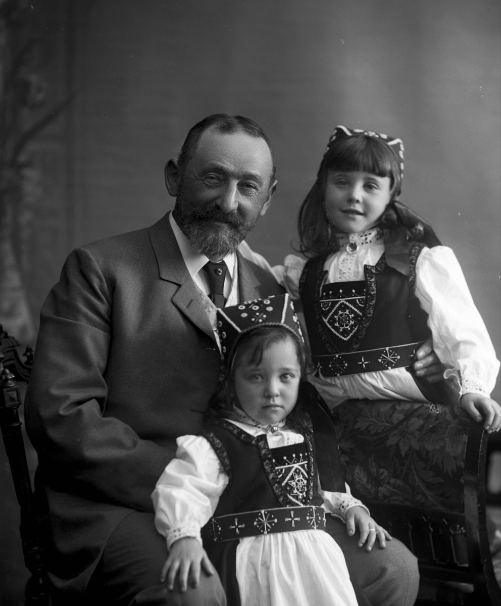 Gustav Borgen, Gruppeportrett, familiebilde. Voksen mann med to småpiker i bunad.