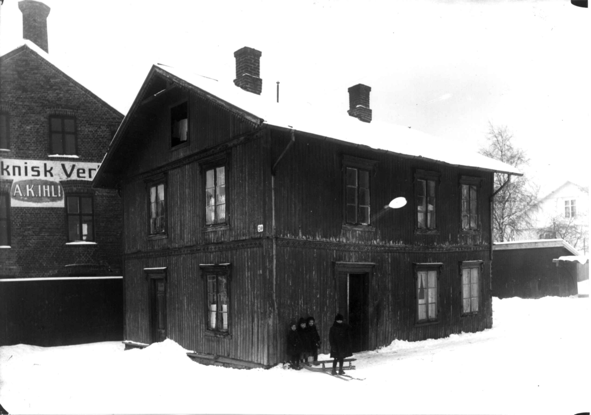 Nanna Broch, Bolighus, trebygning uten grunnmur, ant. Dynekilgata (20), Rosenhoff, Oslo. Jfr. NF.13400-064. Barn med kjelke foran huset. Fra boliginspektør Nanna Brochs boligundersøkelser i Oslo 1920-årene.
