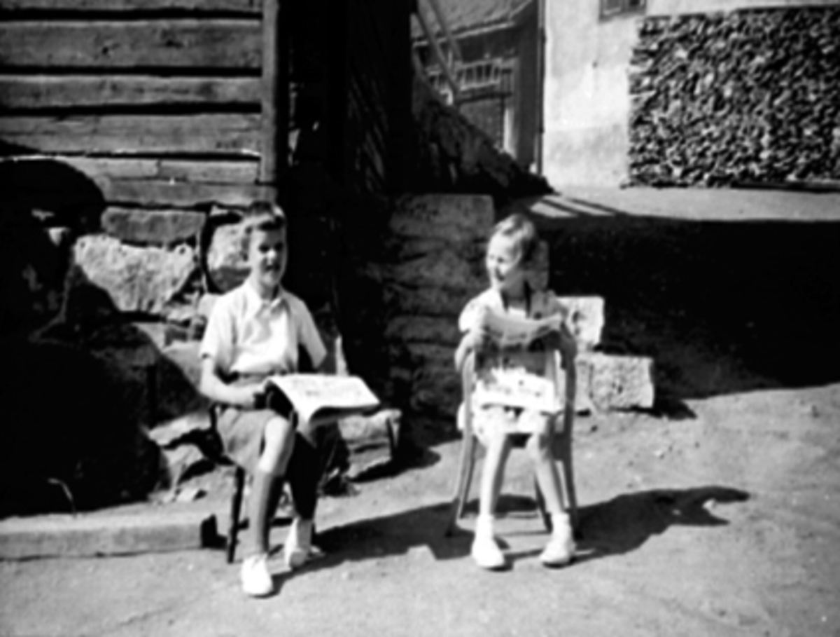 Anno Domkirkeodden, Brannvakta, Grønnegata 70, Hamar. Bakgård, barn. F.v. Finn Marthinsen, Bjørg Nybakken leser avis.