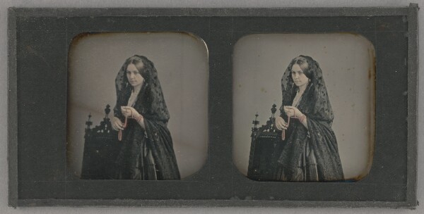 Unknown, [Young woman in veil standing, holding beads]