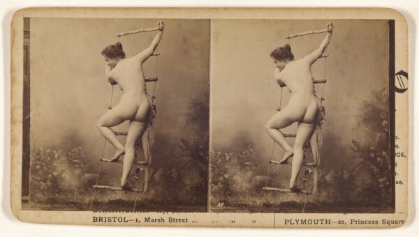 Unknown, [Nude woman with back to camera climbing a makeshift ladder in a studio with floral backdrop]