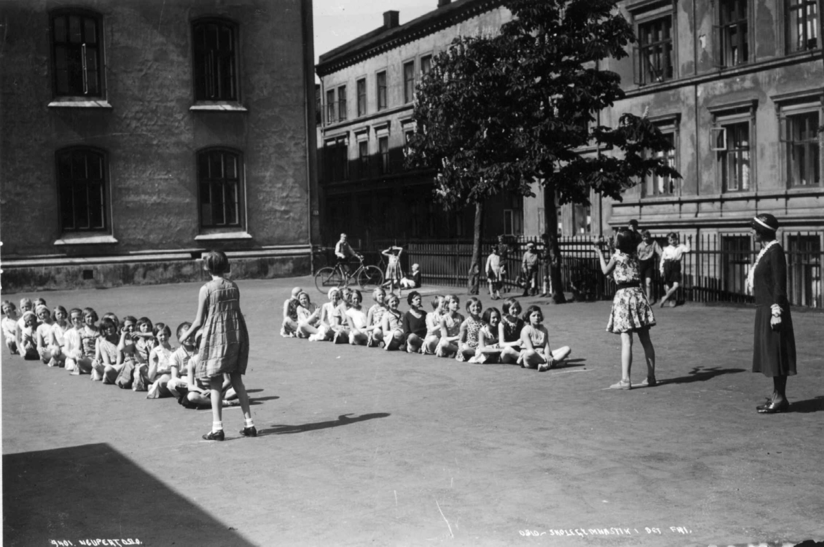 Hermann Christian Neupert, Ruseløkka skole, Oslo. 1932. Småjenter spiller ballspill under oppsyn av en lærerinne.