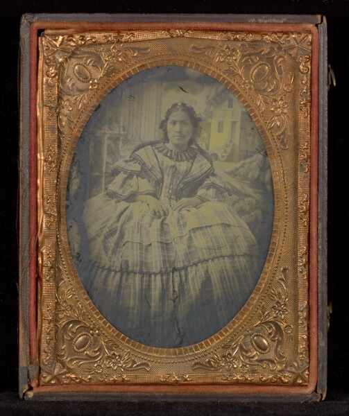 Unknown, [Portrait of a Woman in a Full-skirted Dress in a Studio with a Painted Background]
