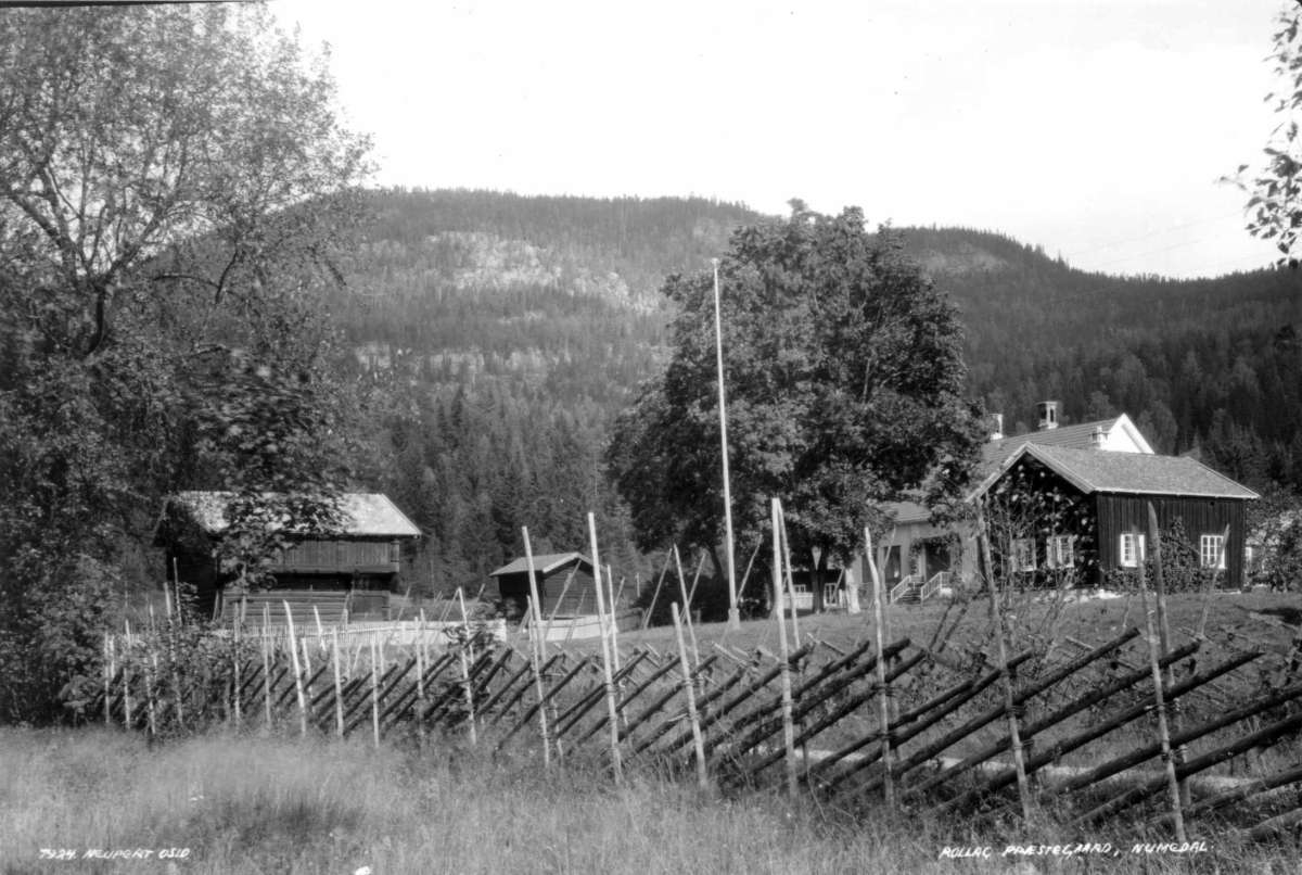 Hermann Christian Neupert, Rollag prestegård, Rollag, Buskerud. 1930. Gårdstun med skigard i forgrunnen. Hovedhus og loft. Skogkledd ås i bakgrunnen.
