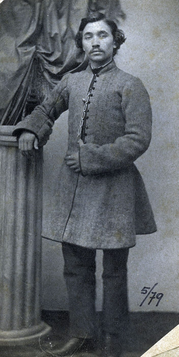Nežinomas fotografas, Jaunuolio pusilgiais plaukais, stovinčio prie puskolonės, portretas