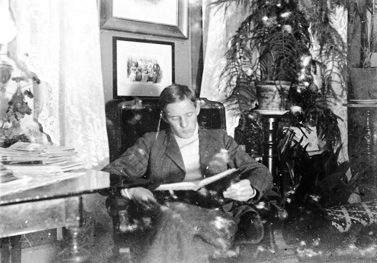Anno Domkirkeodden, Interiør, stue, Granerud gård, Brumunddal. Karl Løken Jr. leser i en bok. Forfatter av boka "Karjoldoktorn"