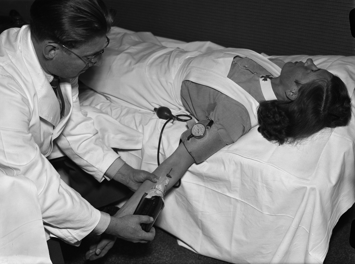 Paul Sandberg, "Personalen på Ulleråker lämnar blod till armén" - läkaren Evert Ljungberg tappar blod från personal på Ulleråkers sjukhus, Uppsala oktober 1941