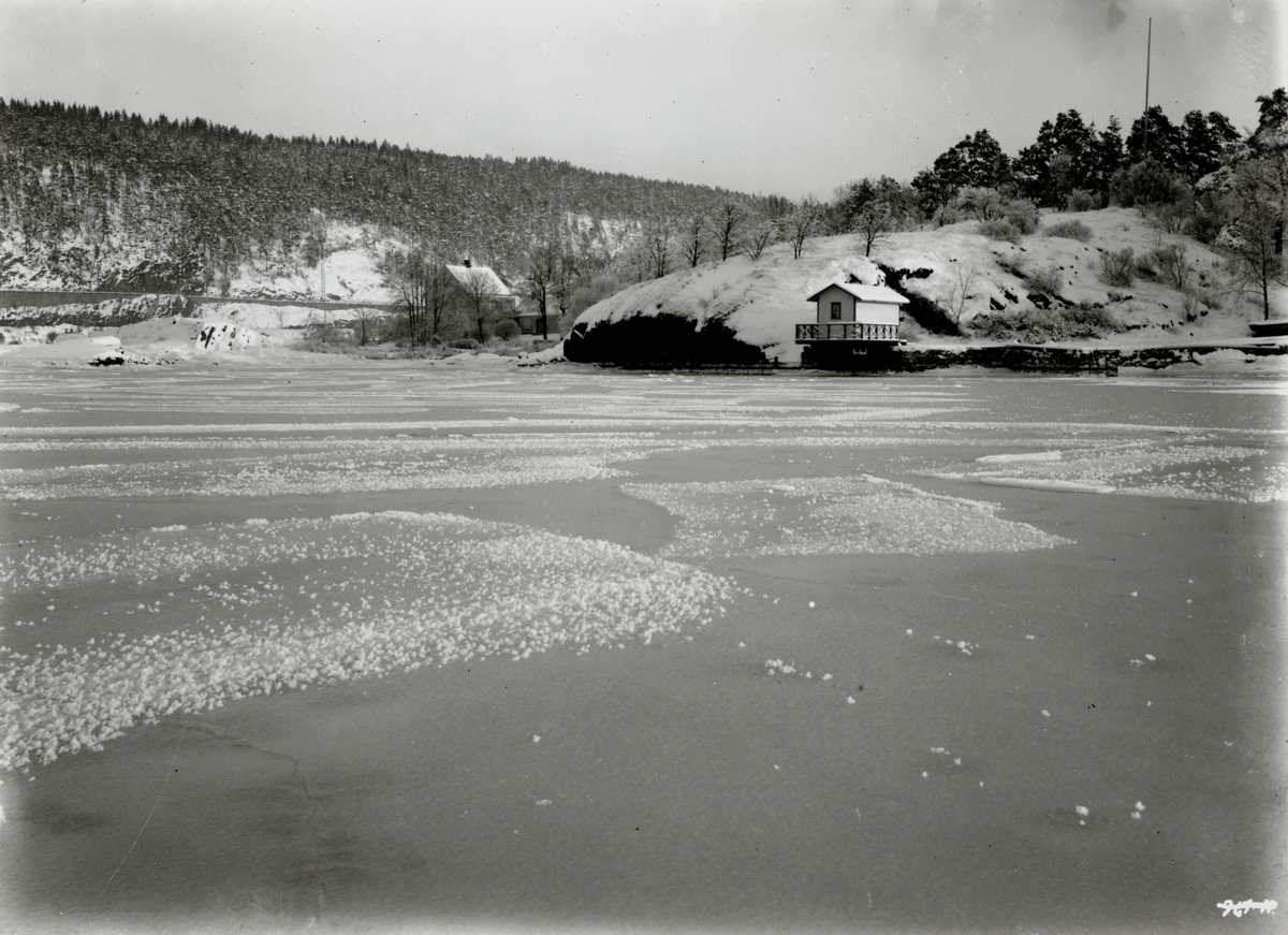 Hermann Christian Neupert, Oslo, Sjursøya 1908. Vinterbilde tatt fra isen. Brygge med badehus. Islagt fjord.