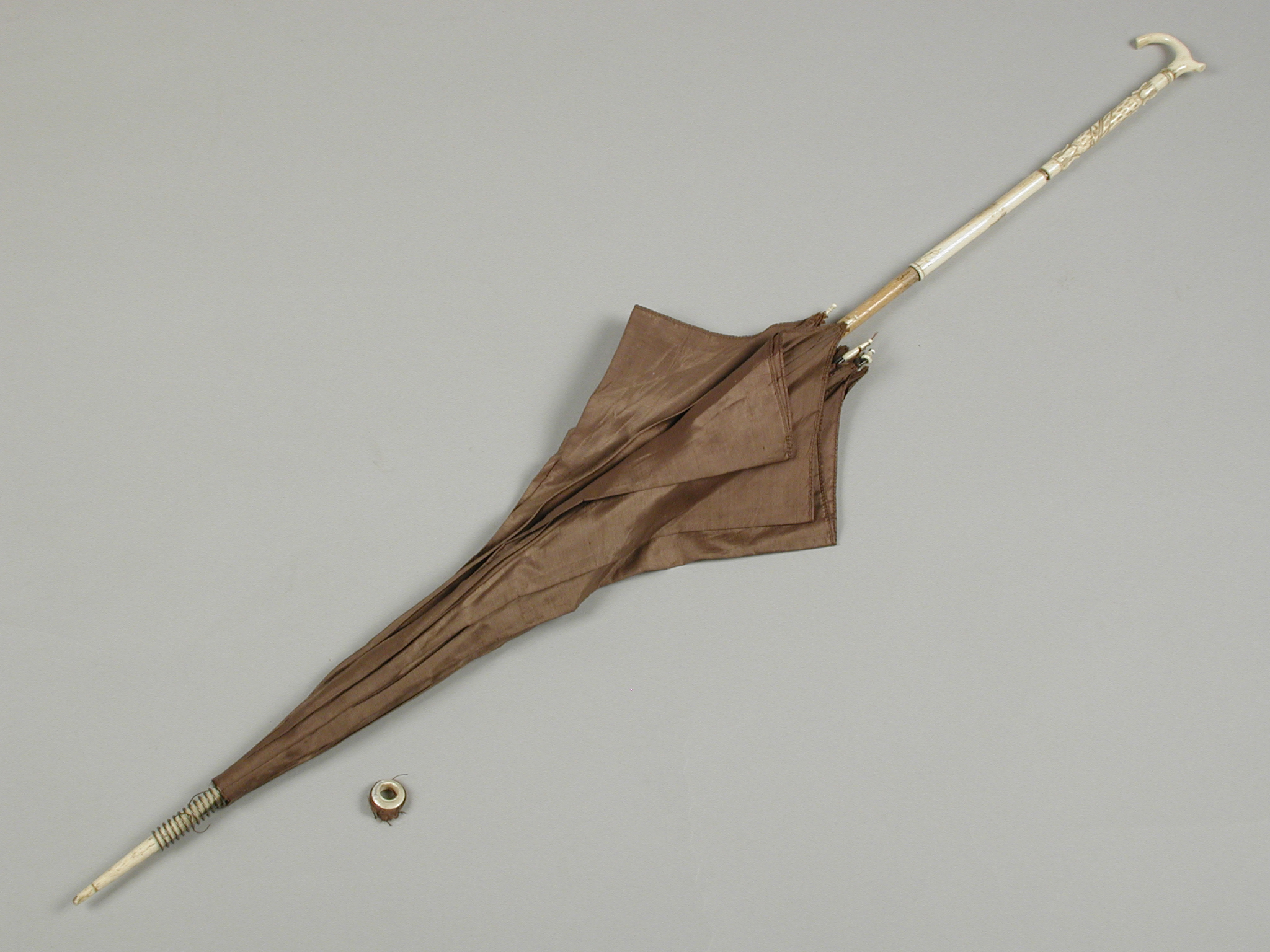 Unknown artist, Parasol met bruine bekleding van zijde, steel deels van hout, deels van bewerkt ivoor, losse ring