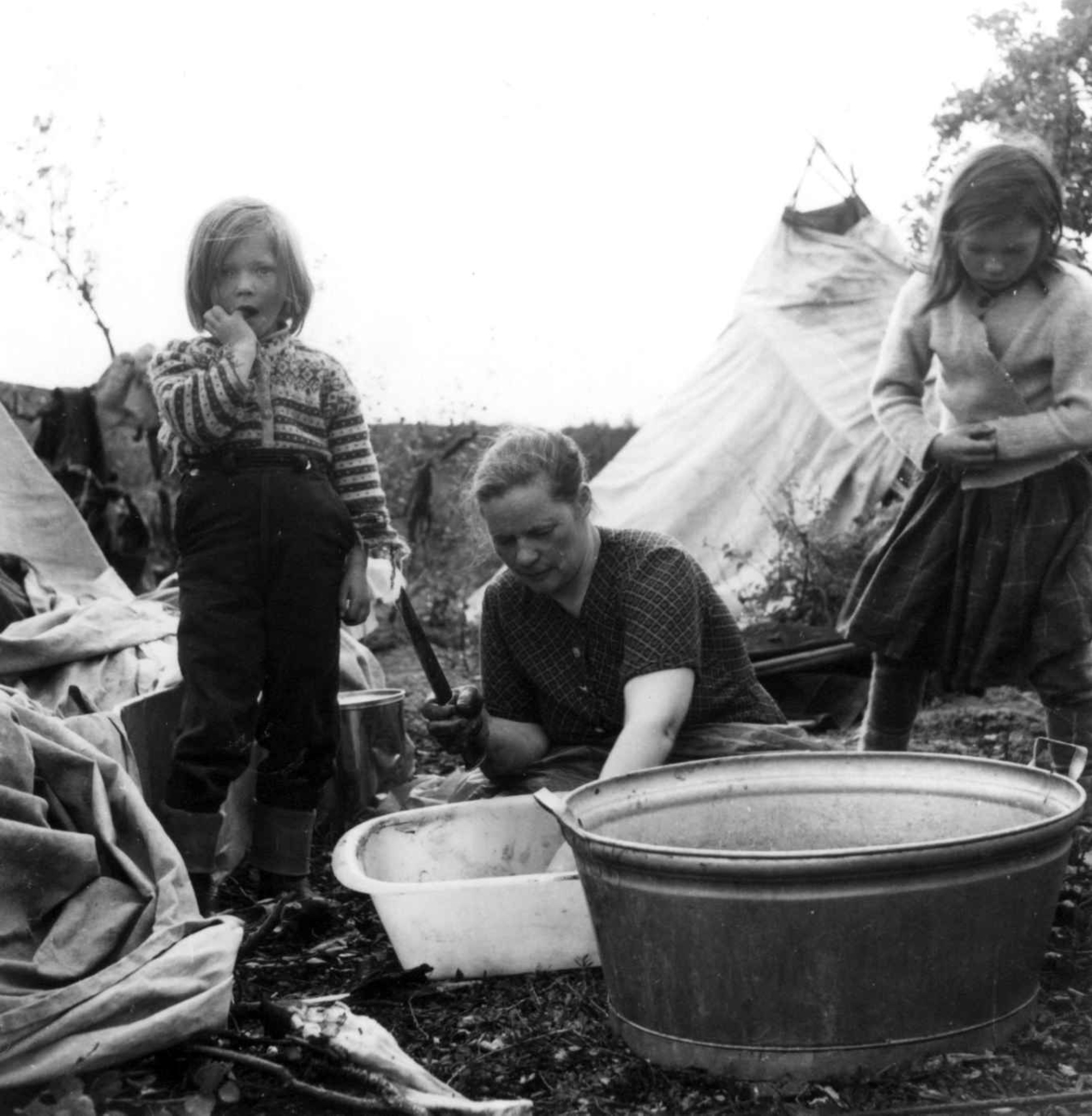 Virginia Raymond Davidson, Ellen Marie Anti tar oppvasken sammen med to barn, Ytre Billefjord, Porsanger, Finnmark, 1959.