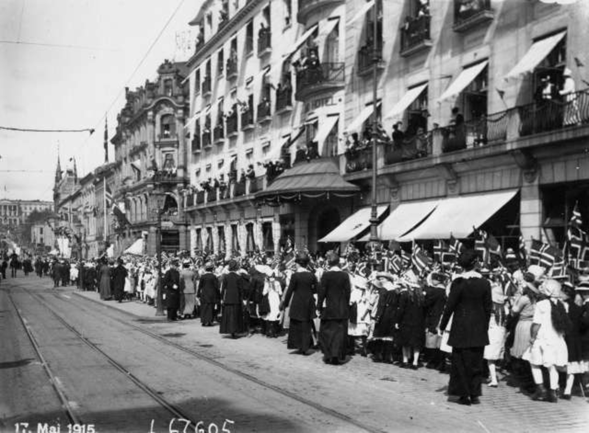 Hermann Christian Neupert, Oslo. 17. mai-tog 1915 ved Grand hotell på vei opp mot Slottet i bakgrunnen. Publikum på balkongene på Grand hotell.
