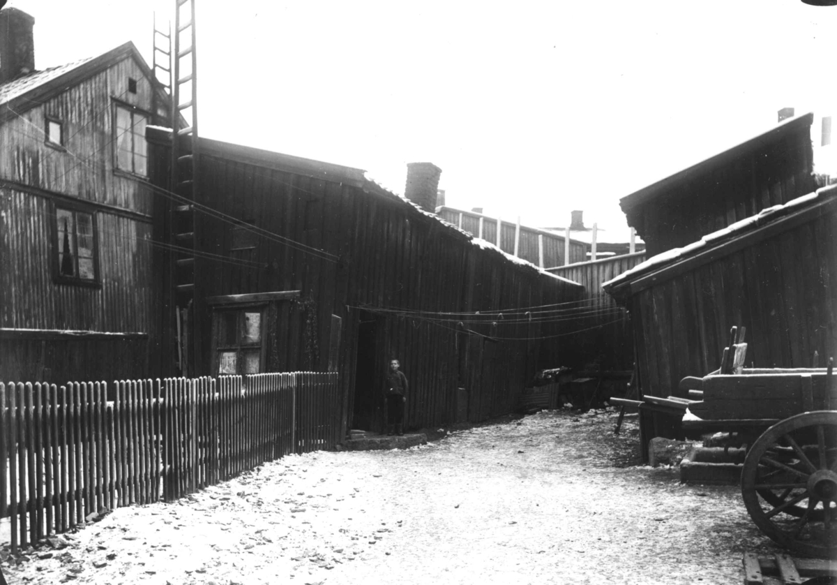 Nanna Broch, Gårdsrom med bolighus og vognskur (?), vogner plassert på gårdsplassen. Muligens Rodeløkka, Oslo. Fra boliginspektør Nanna Brochs boligundersøkelser i Oslo 1920-årene.