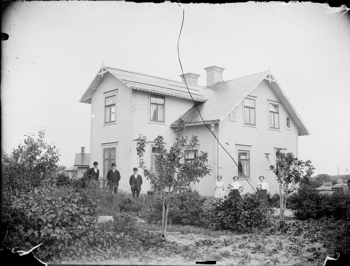 Skötsner-Edhlund, Män och kvinnor i trädgården vid ett bostadshus, Östhammar, Uppland omkring 1910